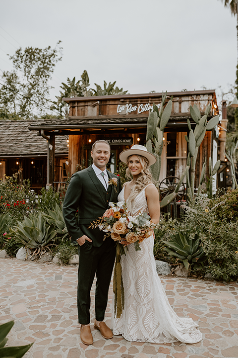 Bride and groom share a romantic moment at their rustic terracotta and forest green wedding