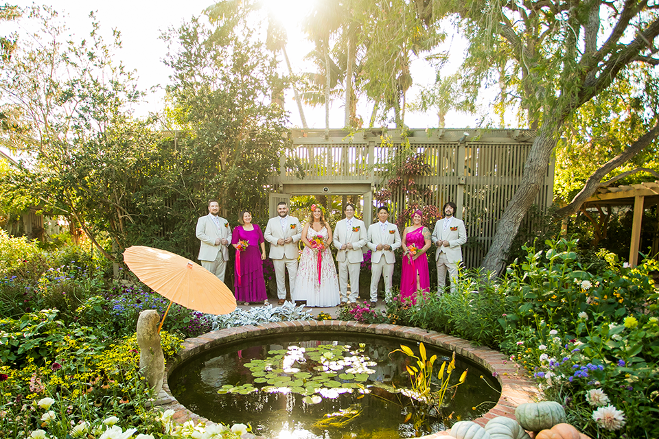Bridal party with bride and groom behind pond