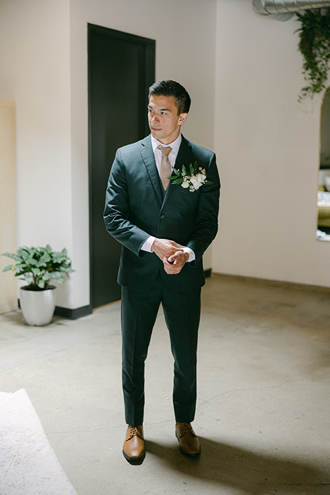Groom in a classic dark suit setting the wedding table.