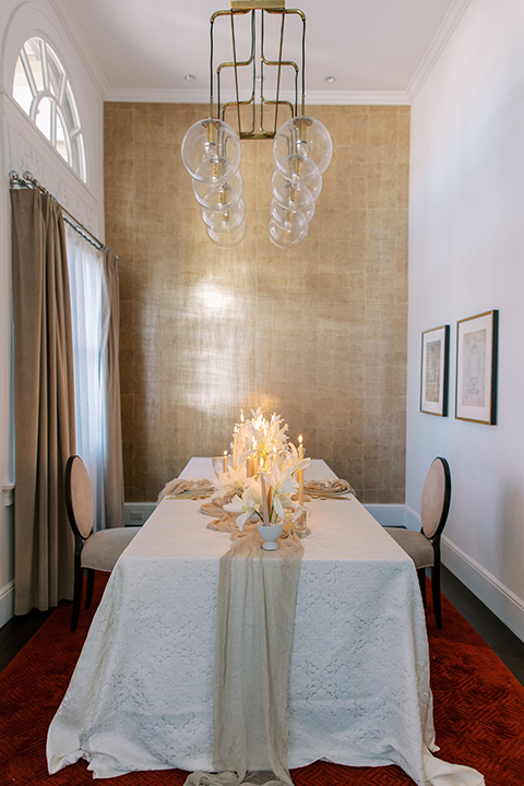 A sophisticated wedding tablescape featuring crystal glassware, gold accents, and ivory floral arrangements, set against the timeless elegance of the US Grant House.