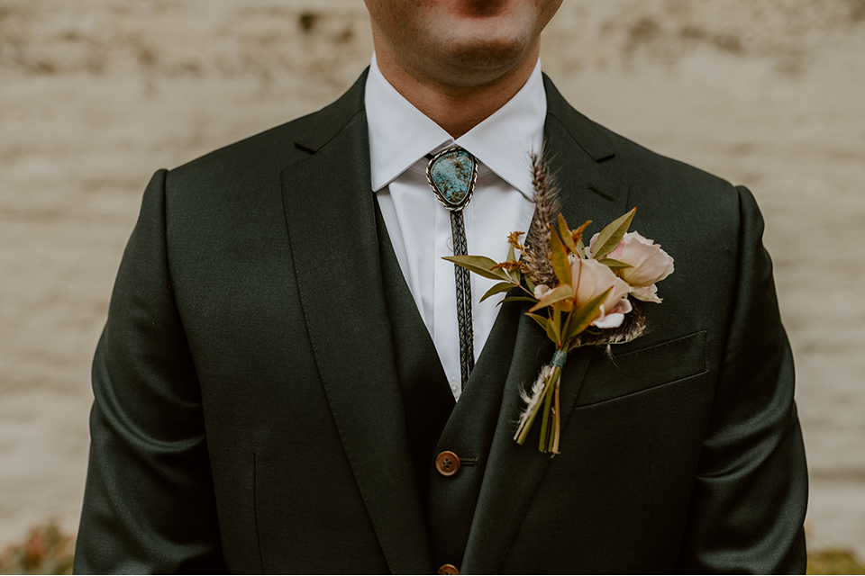 Groom in a stylish suit posing confidently on his wedding day.