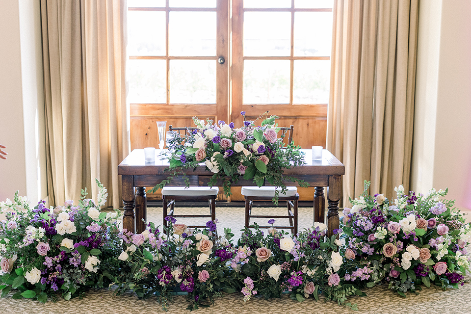 Reception decor with white table linens and purple decor elements