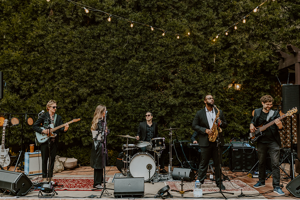 Live band performing at a rustic boho wedding, creating a lively and intimate atmosphere with music and energy