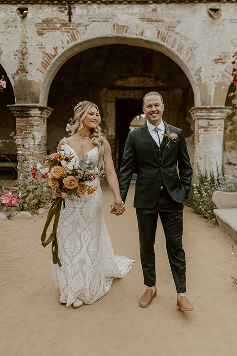 Bride and groom share a romantic moment at their rustic terracotta and forest green wedding