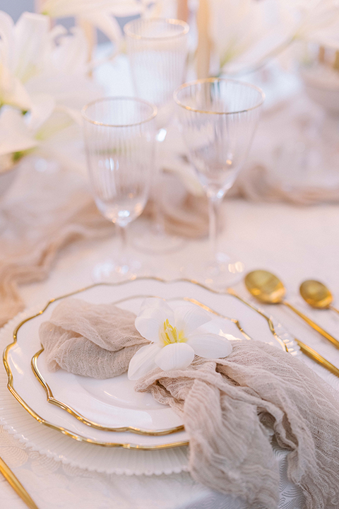 A sophisticated wedding tablescape featuring crystal glassware, gold accents, and ivory floral arrangements, set against the timeless elegance of the US Grant House.