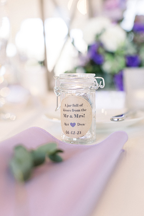 Reception decor with white table linens and purple decor elements