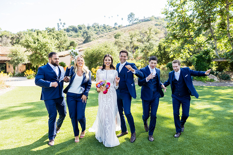weddign party in navy suits dancing with the bride and groom