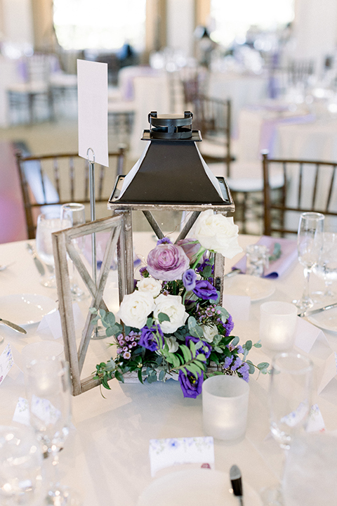 Reception decor with white table linens and purple decor elements