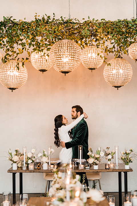 Bride and groom share a romantic moment on the runway at Hangar 21, with golden-hour lighting and a stunning white rose bouquet.