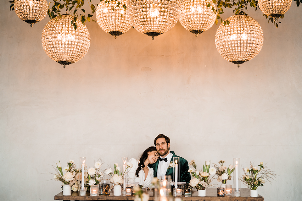 Bride and groom share a romantic moment on the runway at Hangar 21, with golden-hour lighting and a stunning white rose bouquet