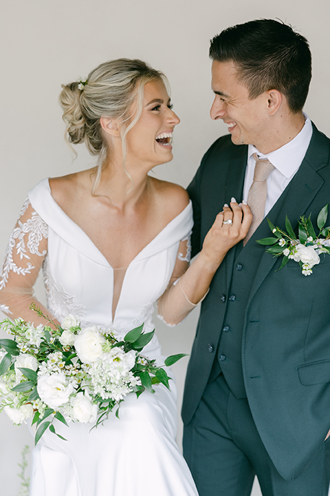 Bride and groom standing at an elegantly styled wedding table with greenery and candlelight.