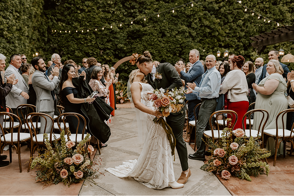 Bride and groom share a romantic moment at their rustic terracotta and forest green wedding