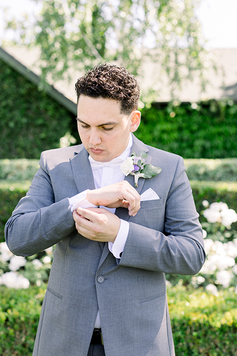 groom in a gray suit with white shirt and bow tie, with a matching white pocket square