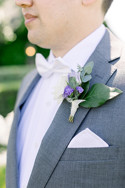 groom in a gray suit with white shirt and bow tie, with a matching white pocket square
