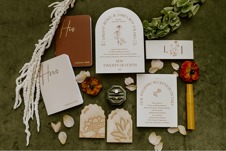 Charming rustic boho wedding details, including hand-lettered signage and a beautifully designed seating chart, surrounded by greenery and wooden accents