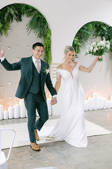 Groom in a classic dark suit setting the wedding table.