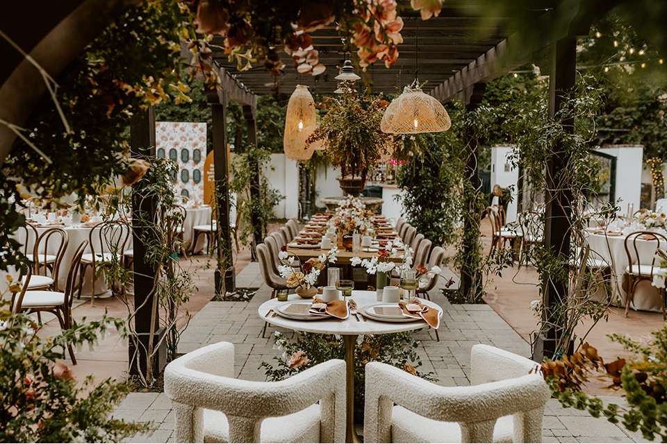 Warm and inviting rustic boho wedding reception setup with wooden tables, candles, and floral centerpieces, creating a cozy, intimate atmosphere